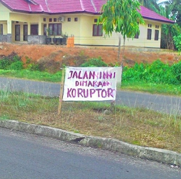 "This road consumed by corruptors". Photo courtesy of Visual Jalanan.